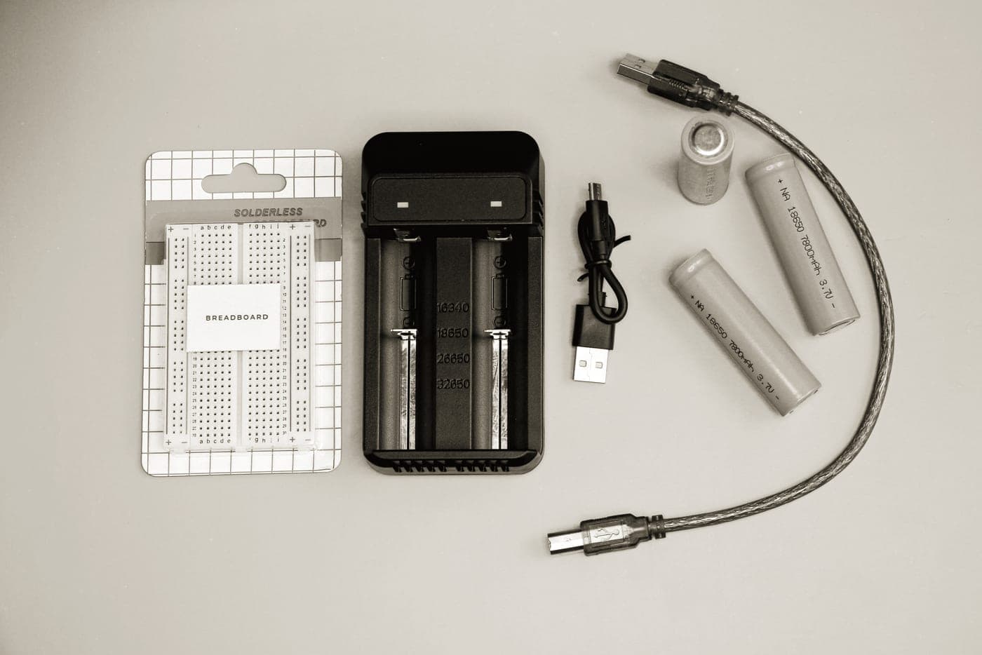A lithium battery pack and charging cable on a work surface