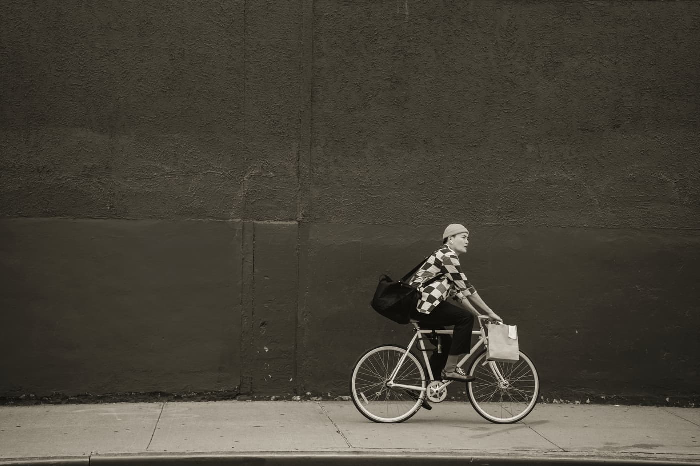 A bicycle leaning against a wall on a city street