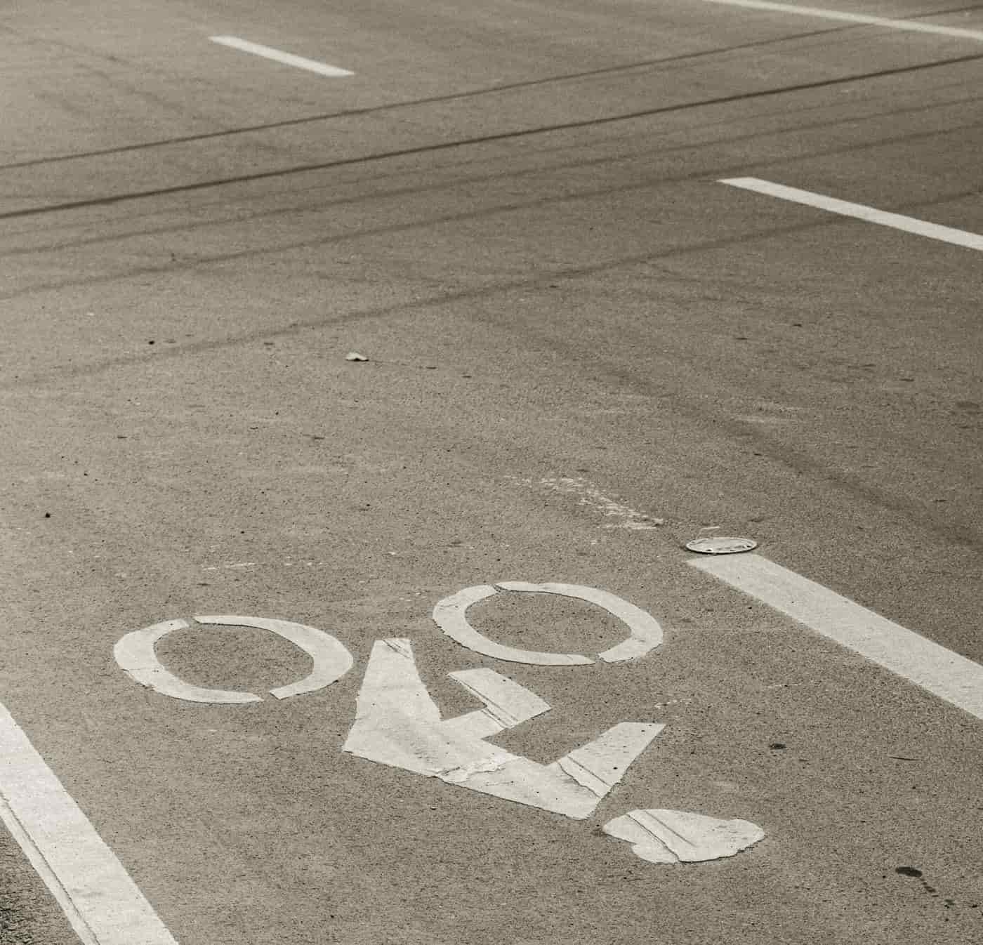 A marked bike lane running alongside a row of parked cars