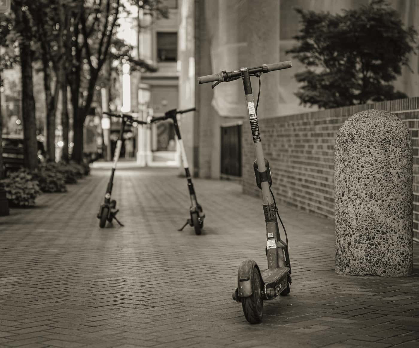 A large-framed electric scooter with a wide deck standing on asphalt