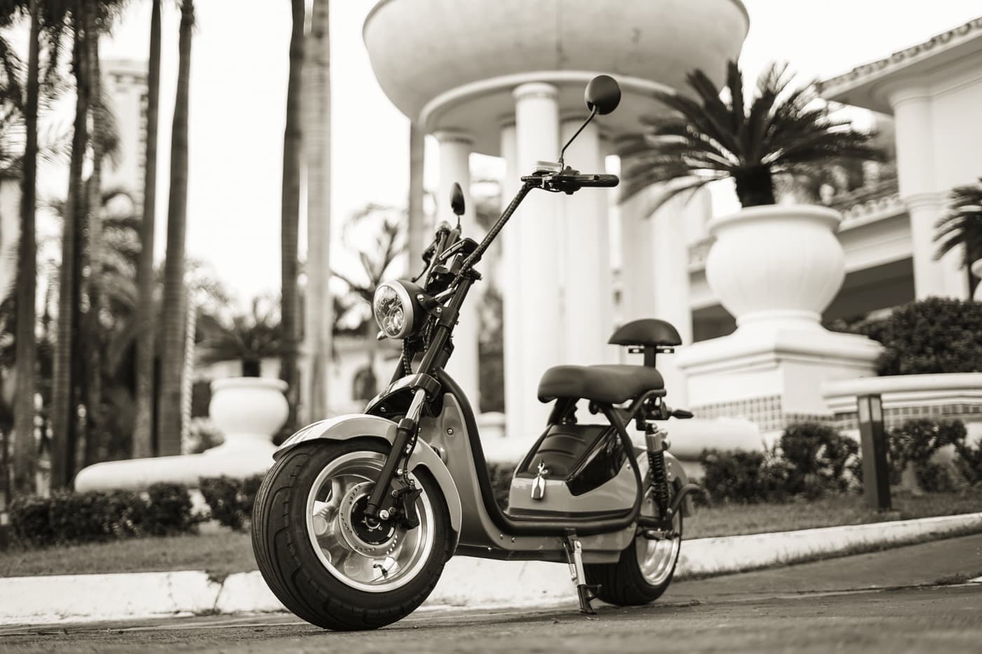 A seated moped-style electric scooter parked on a quiet street