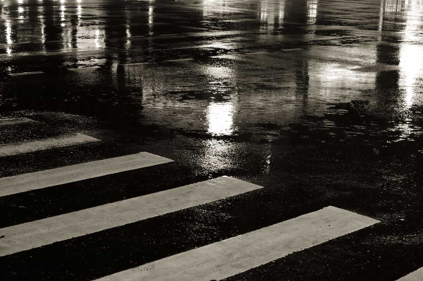 A wet city road surface reflecting light after rain